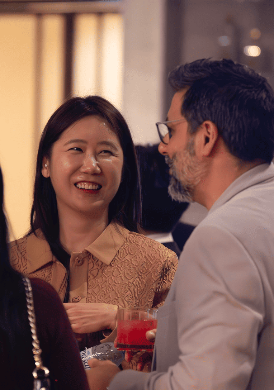 Two participants smiling and engaging in conversation during AGCC Korea Tech Demo Day 2024 networking session.