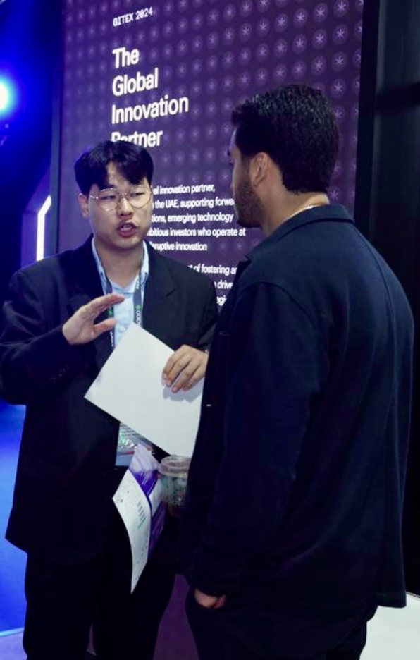 Representative from Hyper Accel discussing innovative solutions with a visitor at the AGCC booth during Expand North Star 2024