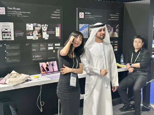 Representative from SooHouse startup with an Emirati visitor at the AGCC booth during Expand North Star 2024, engaging in conversation about the startup’s offerings.